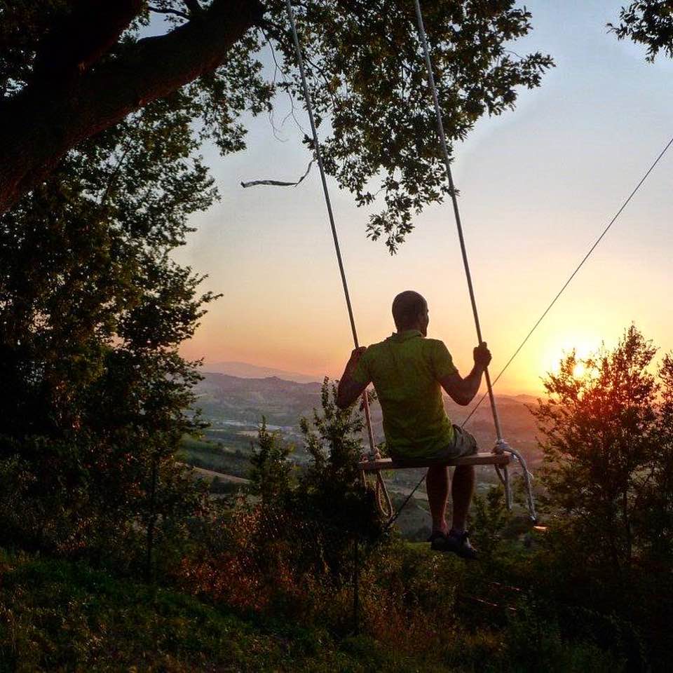 Man on swing at sunset